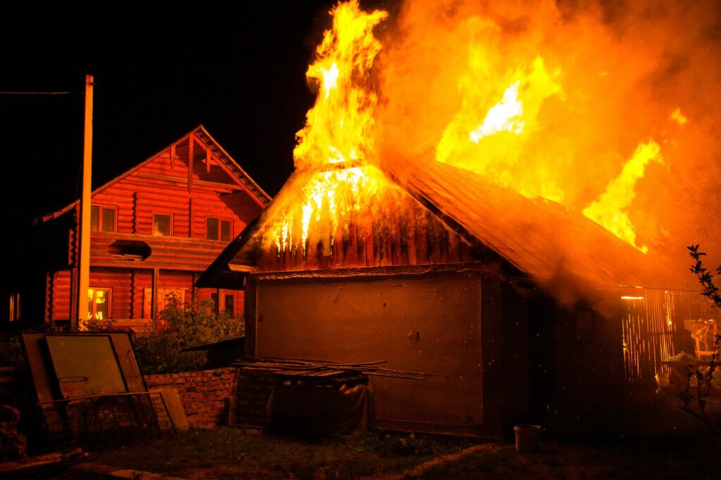 Wooden house or barn burning on fire at night